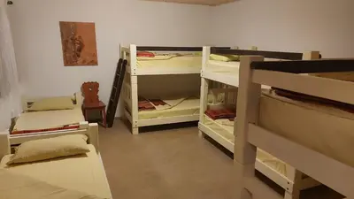 a room with several bunk beds in a room at Tičarjev Dom at Vrsic pass in Soča