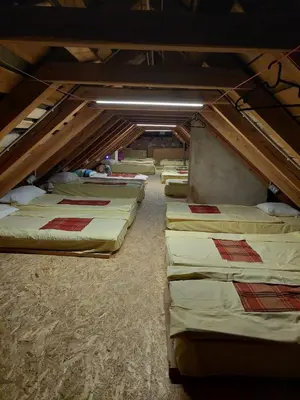 a row of mattresses are lined up in a room at Tičarjev Dom at Vrsic pass in Soča