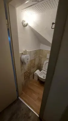 a small bathroom with a toilet and a staircase at Tičarjev Dom at Vrsic pass in Soča