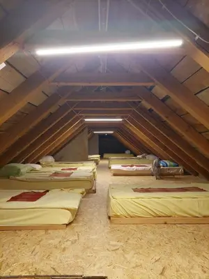 a room with three beds in a attic at Tičarjev Dom at Vrsic pass in Soča