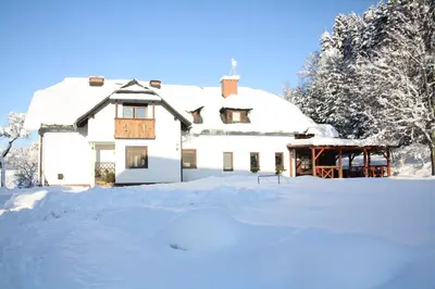 a house covered in snow in a yard at Eco tourist farm Mikl in Prevalje