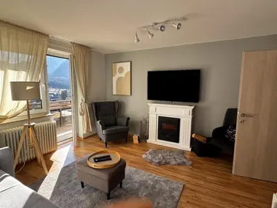a living room with a fireplace and a flat screen tv at Rož'ca apartments with mountain view in Mojstrana