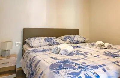 a bed with blue and white sheets and pillows at Apartment Mari in Bohinj