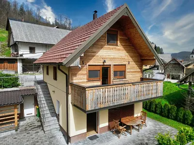 a wooden house with a deck and a patio at Apartment Mari in Bohinj