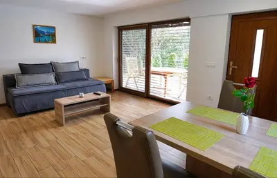 a living room with a blue couch and a table at Apartment Mari in Bohinj