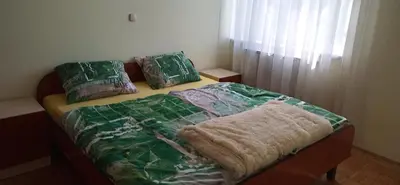 a bed with a blanket and pillows on it at Apartma Rogaska riviera in Rogaška Slatina