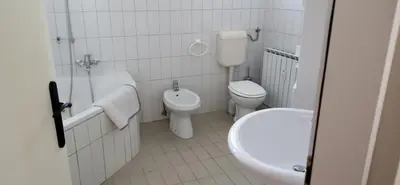 a white bathroom with a toilet and a sink at Apartma Rogaska riviera in Rogaška Slatina