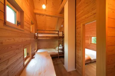 a bedroom in a log cabin with two beds at Granaries Pear & Walnut in Tolmin