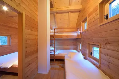 a bedroom in a log cabin with two beds at Granaries Pear & Walnut in Tolmin