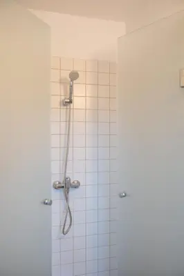 a shower with a shower head in a bathroom at Guesthouse Novak in Dvor
