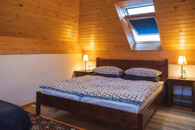 a bedroom with a bed in a wooden room at Guesthouse Novak in Dvor
