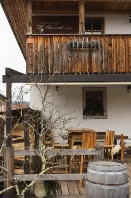 a building with a balcony and a table and chairs at Guesthouse Novak in Dvor