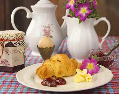 a plate with a croissant and other foods on a table at Guesthouse Novak in Dvor