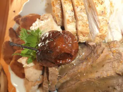 a plate of food with meat and gravy and a fork at Turistična kmetija Ramšak in Zreče