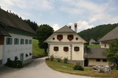 a white house with red flowers on the windows at Apartments Cvetje v Jeseni in Škofja Loka