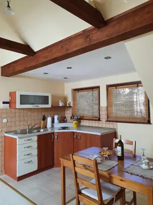 a kitchen with wooden cabinets and a table and a table sidx sidx sidx at Hiška pri Tisi in Ptujska Gora