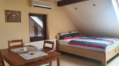 a bedroom with a bed and a table and a window at Hiška pri Tisi in Ptujska Gora