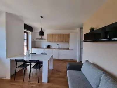 a kitchen and living room with a table and chairs at Apartments Pri Jakobu in Kobarid
