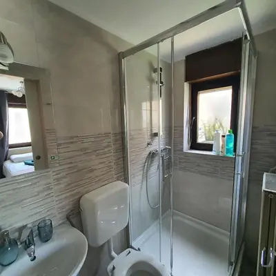 a bathroom with a shower and a toilet and a sink at DEKO-rooms in Ljubljana
