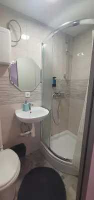 a bathroom with a shower and a toilet and a sink at DEKO-rooms in Ljubljana