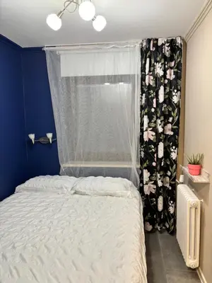 a bedroom with a bed and a window with a curtain at DEKO-rooms in Ljubljana