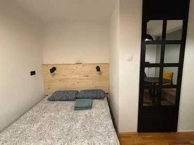 a bedroom with a bed and a black door at DEKO-rooms in Ljubljana