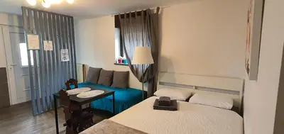 a room with two beds and a table and a couch at DEKO-rooms in Ljubljana