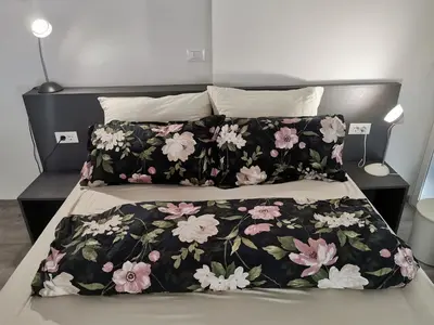 a bed with a black blanket with flowers on it at DREAMY CENTER LOCATION in Ljubljana