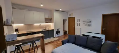 a living room with a couch and a kitchen at Apartma Valan in Bovec