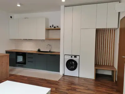 a kitchen with white cabinets and a washing machine at Apartma Valan in Bovec
