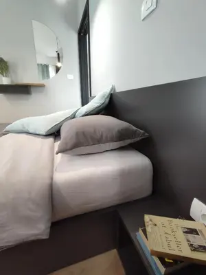 a bed with two pillows on it next to a table at Boutique rooms by Petrič winery in Dobravlje