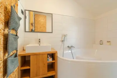 a bathroom with a white tub and a sink at Holiday Home Lukc with free parking in Kobarid