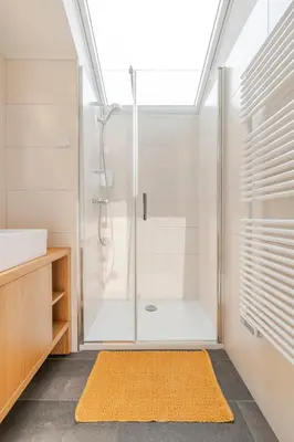 a bathroom with a shower and a yellow rug at Holiday Home Lukc with free parking in Kobarid