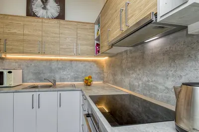 a kitchen with a sink and a clock on the wall at Pool & Whirlpool Art Villas in Trebnje