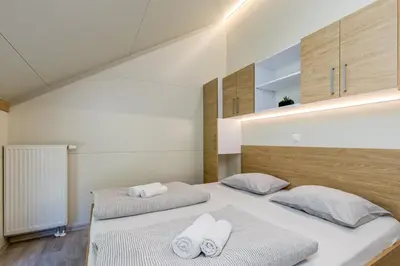 two beds in a bedroom with white towels at Pool & Whirlpool Art Villas in Trebnje