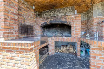a brick kitchen with a brick oven in a building at Pool & Whirlpool Art Villas in Trebnje