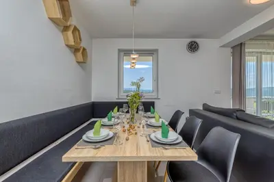 a dining room with a wooden table and chairs at Pool & Whirlpool Art Villas in Trebnje