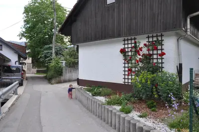 a small child walking down a street next to a building at Vrtnarjeva hiša, The Gardener's Cottage in Radovljica