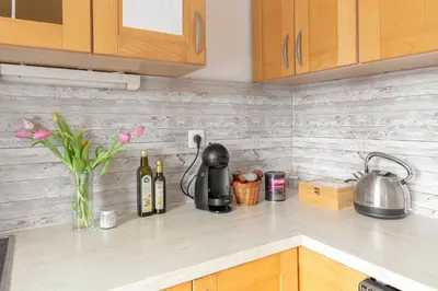 a kitchen counter with bottles of wine and flowers at Vrtnarjeva hiša, The Gardener's Cottage in Radovljica