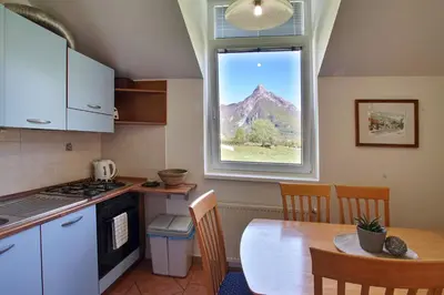a kitchen and dining room with a table and a window at Apartments Jojo in Bovec