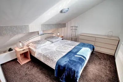 a bedroom with a bed with a blue blanket on it at Apartments Jojo in Bovec