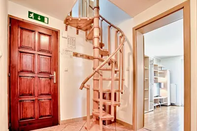 a spiral staircase in a room with a wooden door at Apartments Jojo in Bovec