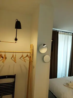 a bedroom with a bed and a rack with hangers at Bed & Breakfast Mozaik in Ljubljana