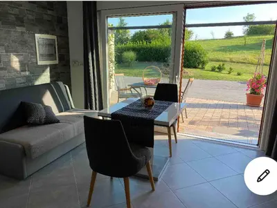 a living room with a table and a couch at Lovely apartment in nature with sauna in Postojna
