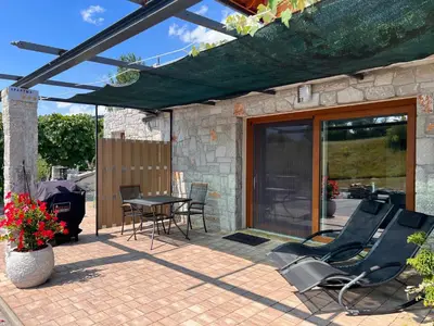 a patio with chairs and a table on a patio at Lovely apartment in nature with sauna in Postojna