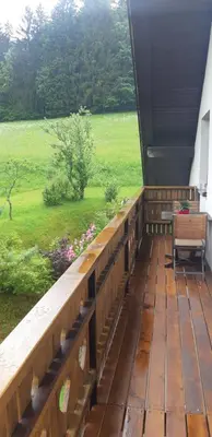 a wooden deck with a view of a field at Sunny place in Kranjska Gora