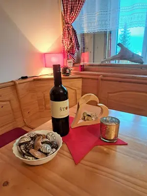 a bottle of wine and a plate of cookies on a table at Sunny place in Kranjska Gora