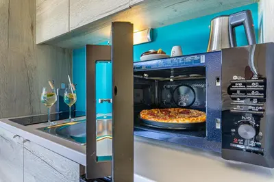a kitchen with a pizza in an oven at Rooftop Home With Whirlpool & Sauna - Happy Rentals in Trebnje