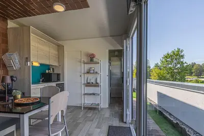 a kitchen and dining area of a tiny house with a balcony at Rooftop Home With Whirlpool & Sauna - Happy Rentals in Trebnje