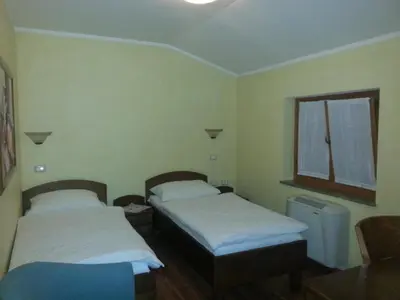 two beds in a small room with a window at Arkade turizem in Črniče